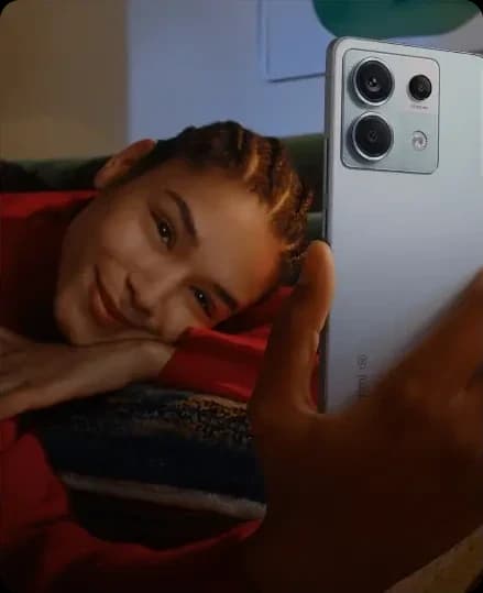 Mujer recostada sonriendo mientras sostiene un smartphone Xiaomi